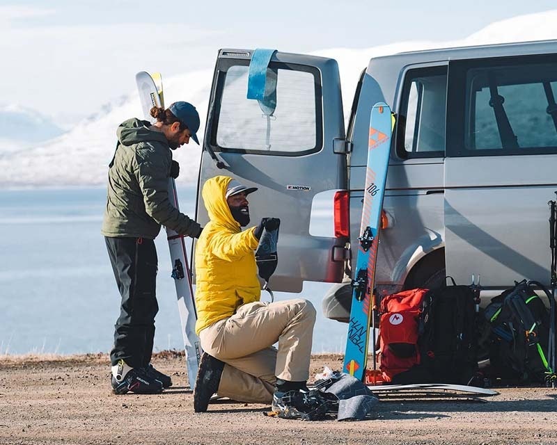 friends packing ski and snowboarding gear into car