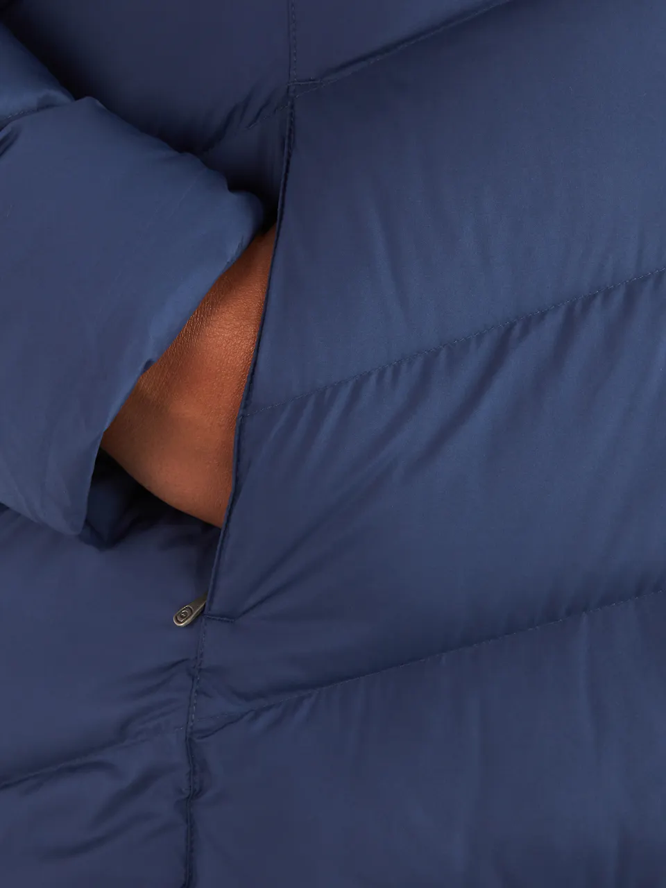 close up of hand in pocket of blue puffer jacket