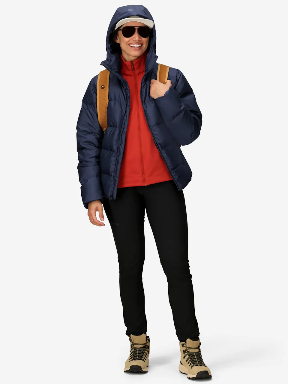 Insulated blue puffer jacket with hood, paired with hiking boots, black pants, and a tan backpack.