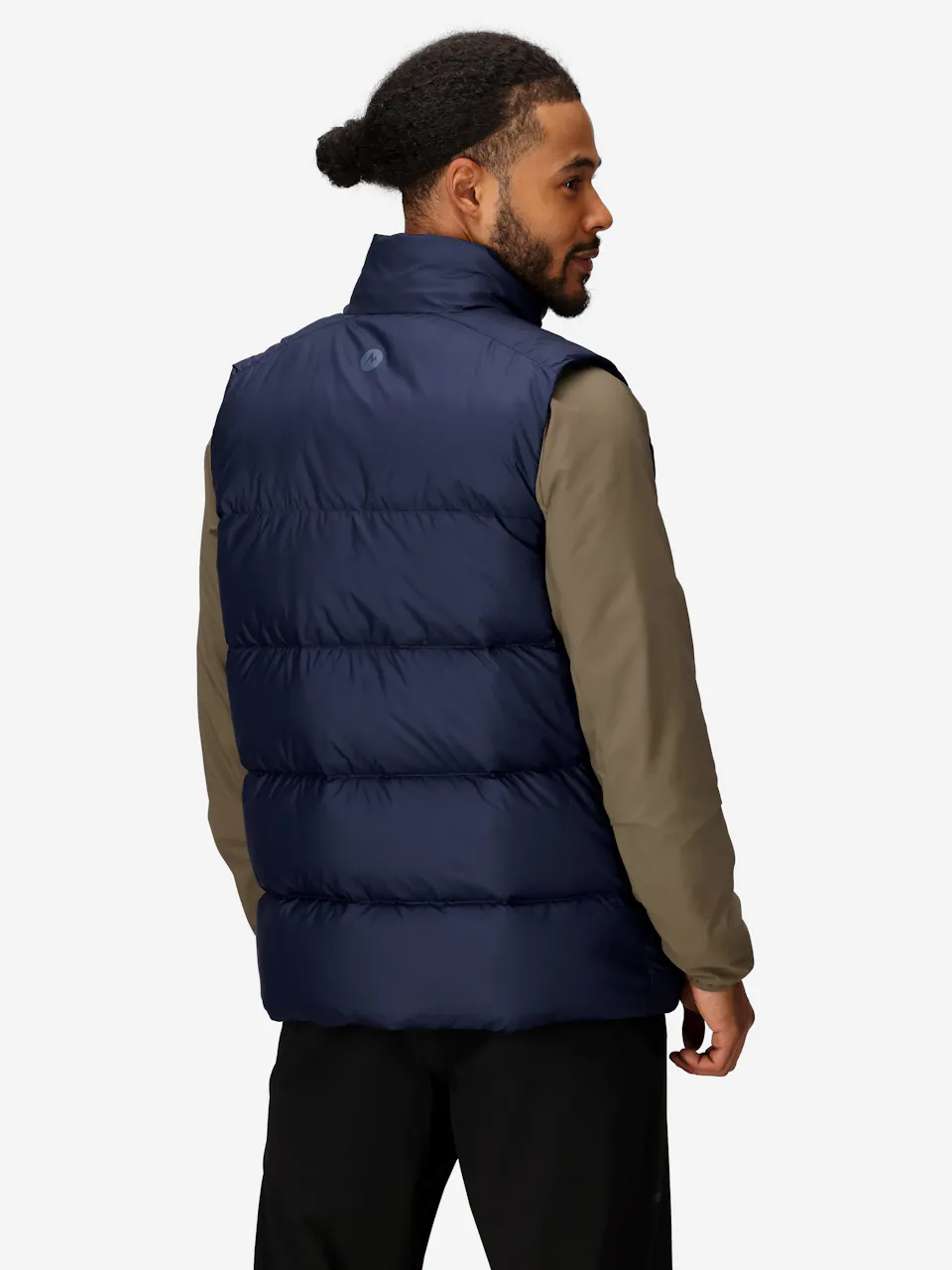 Man wearing a blue puffer vest with high collar and sleeveless design, ideal for outdoor winter layering.