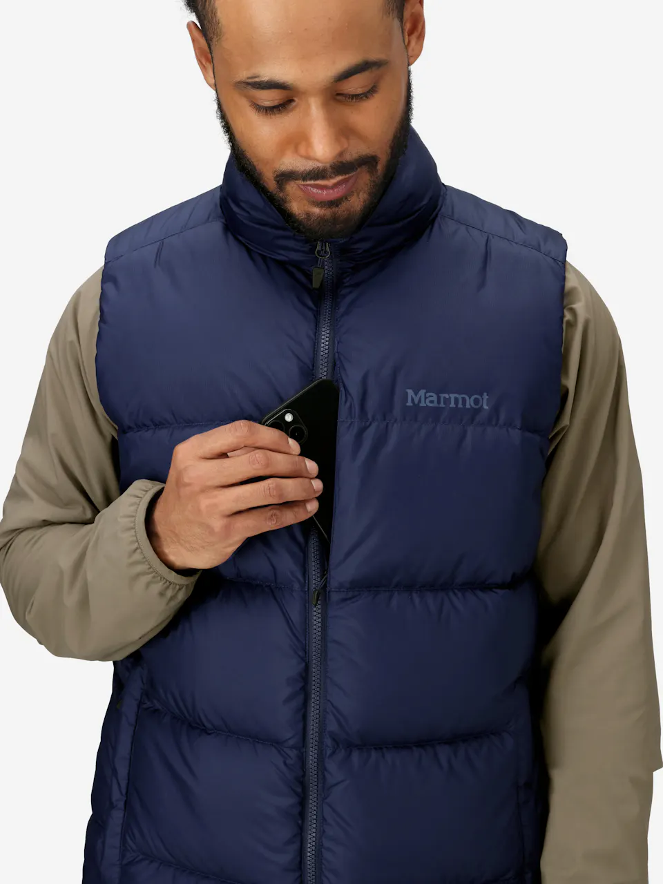 Blue insulated puffer vest with zip closure and chest pocket, shown with person holding a smartphone.