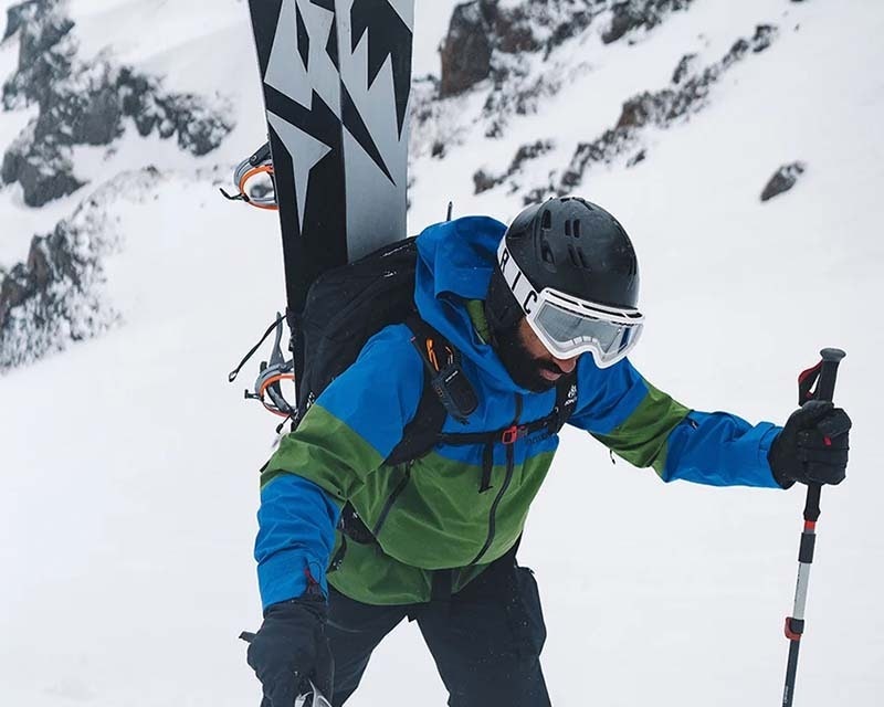 man in outdoor gear preparing to snowboard