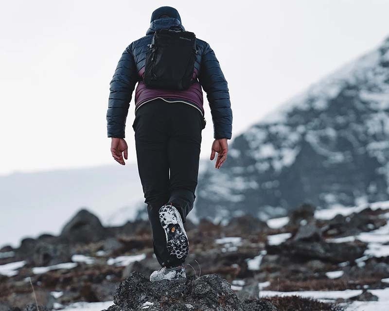 man in outdoor clothing enjoying a hike through the mountains