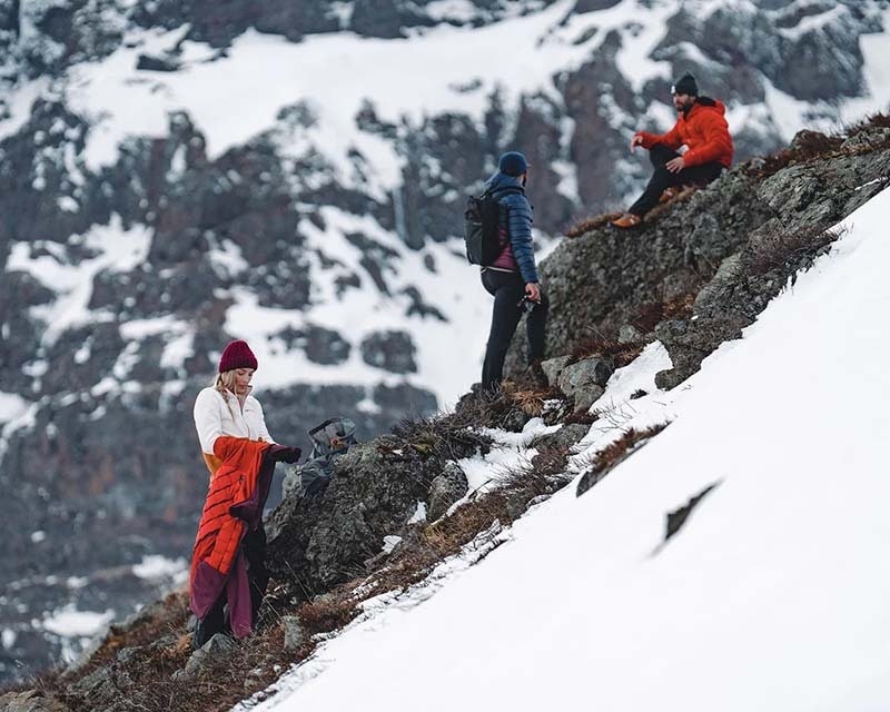 group of friends in outdoor clothing enjoying a hike through the mountains